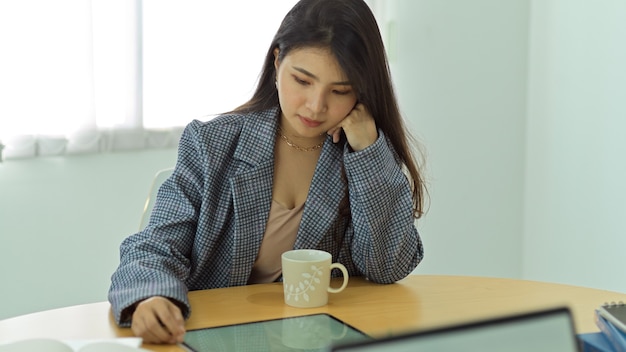 Retrato de mulher de negócios trabalhando com tablet digital na mesa da sala de escritório