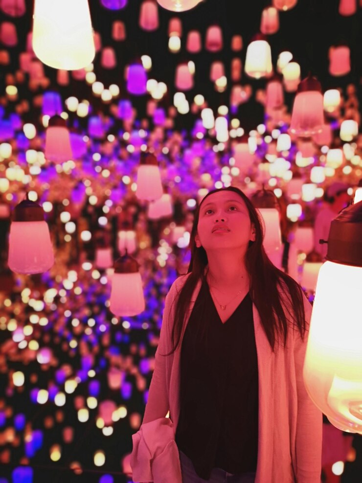 Foto retrato de mulher de pé contra luzes iluminadas
