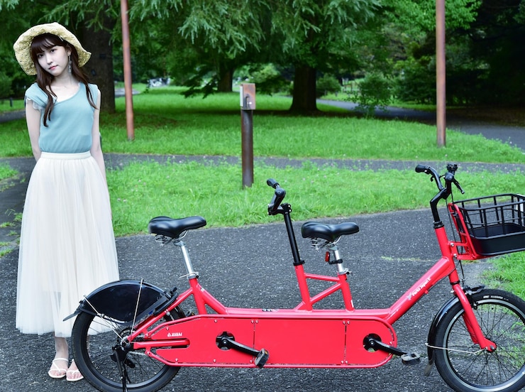 Foto retrato de mulher de pé de bicicleta contra plantas