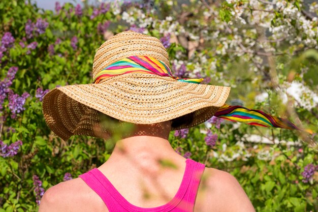 Foto retrato de mulher de trás usando chapéu no jardim de primavera