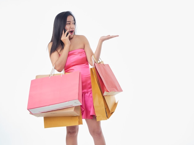 Retrato de mulher de vestido rosa com sacolas de compras isoladas no fundo branco