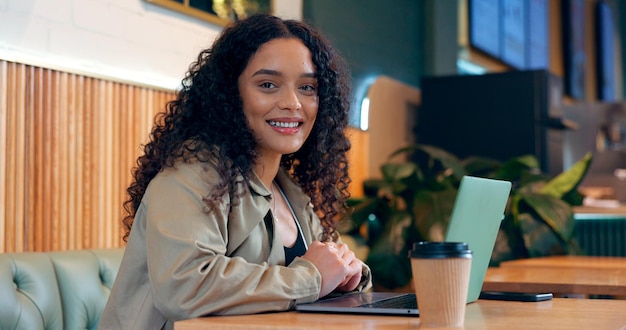 Foto retrato de mulher e laptop em café para trabalho remoto pesquisa ou rede para negócios com sorriso pessoa de rosto e felicidade com tecnologia em café para redação internet e freelancer