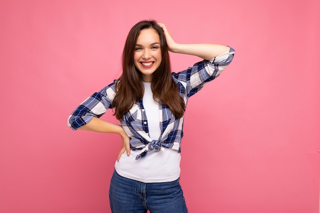 Retrato de mulher elegante alegre positiva em roupa hipster isolado no fundo rosa com espaço de cópia.