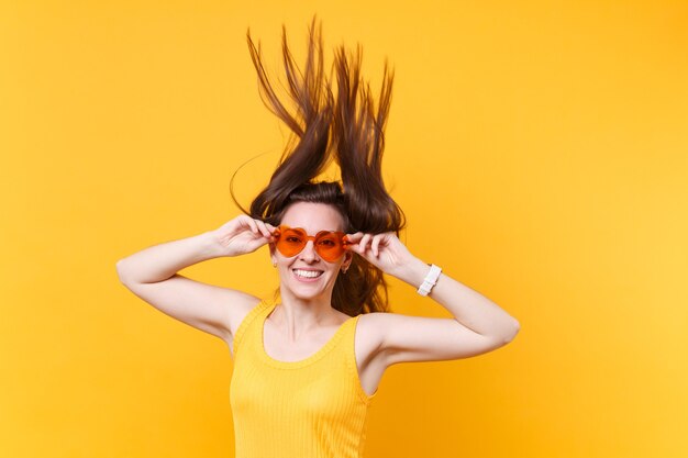 Retrato de mulher em quadrinhos engraçado animado riso alegre em óculos laranja com esvoaçantes cópia espaço de cabelo isolado em fundo amarelo. emoções sinceras de pessoas, conceito de estilo de vida. área de publicidade.