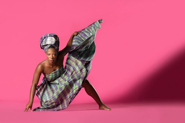 Foto retrato de mulher em traje dançando contra fundo rosa