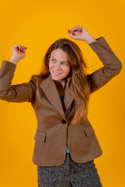 Retrato de mulher em um fundo amarelo em um conceito de moda de jaqueta marrom