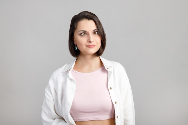 retrato de mulher engraçada morena multiétnica semicerrou os olhos em uma blusa rosa e uma camisa branca