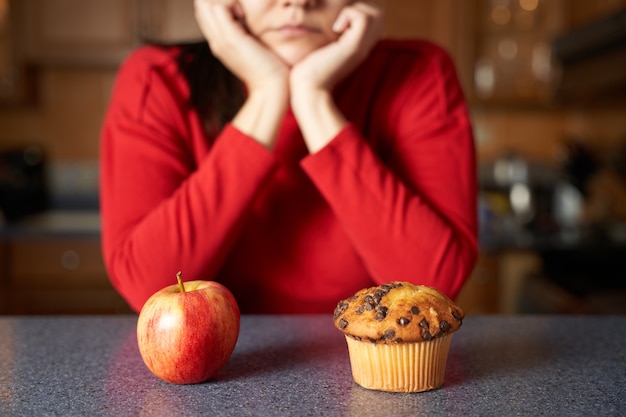 Foto retrato de mulher escolhendo entre junk food e alimentos naturais orgânicos saudáveis