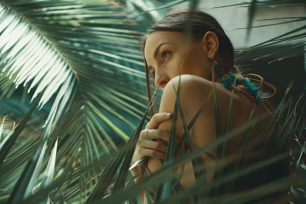 Retrato de mulher exótica entre plantas tropicais, moda, beleza, co