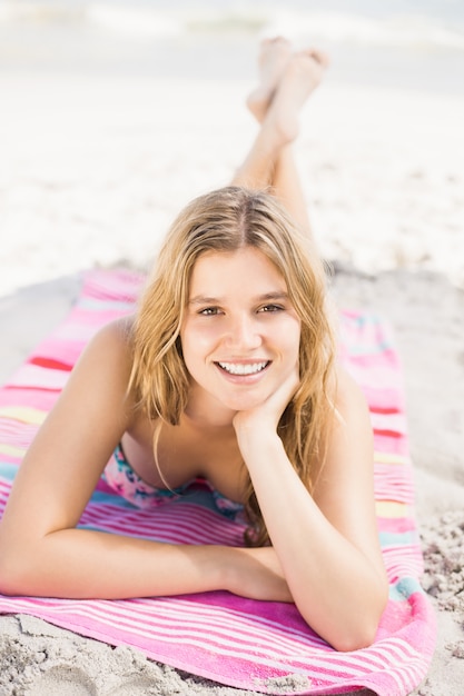 Retrato de mulher feliz em biquíni, deitada na praia