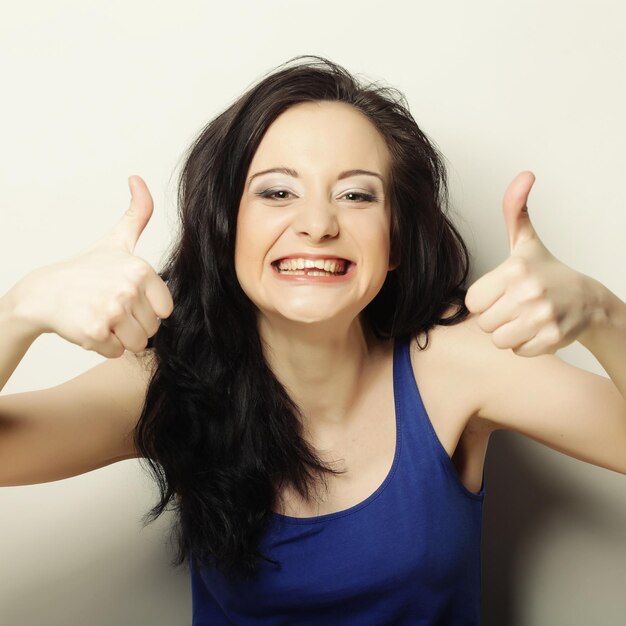 Retrato de mulher feliz, mostrando os polegares