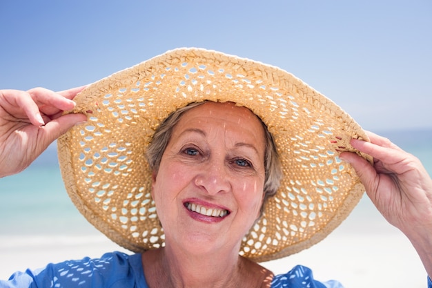 Retrato de mulher feliz sênior no chapéu de praia