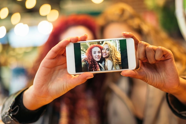 Foto retrato de mulher fotografando com telefone celular