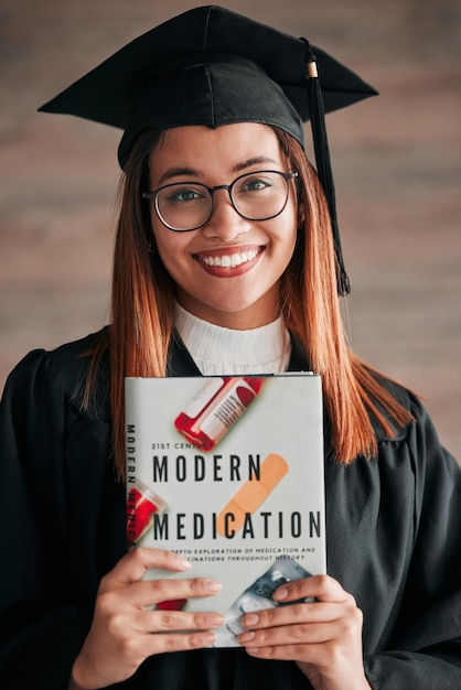 Foto retrato de mulher graduada médica e livro de medicina de um jovem estudante feliz com a graduação aprendendo a felicidade do livro e a mulher animada pronta para o ensino universitário com um sorriso de conhecimento