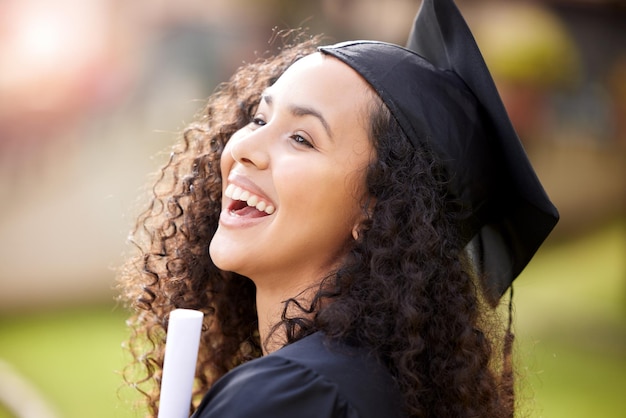 Retrato de mulher graduada na universidade e risada com realização escolar ao ar livre com sorriso e diploma certificado de educação de pessoa do sexo feminino e campus com estudante e felicidade com o sucesso do estudo