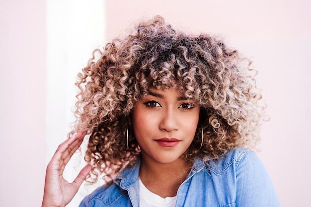 Retrato de mulher hispânica séria e confiante com cabelo afro no estilo de vida urbano da primavera da cidade