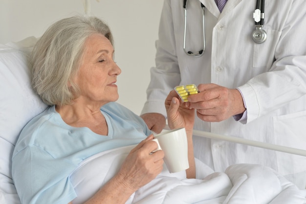 Foto retrato de mulher idosa no hospital tomando comprimidos