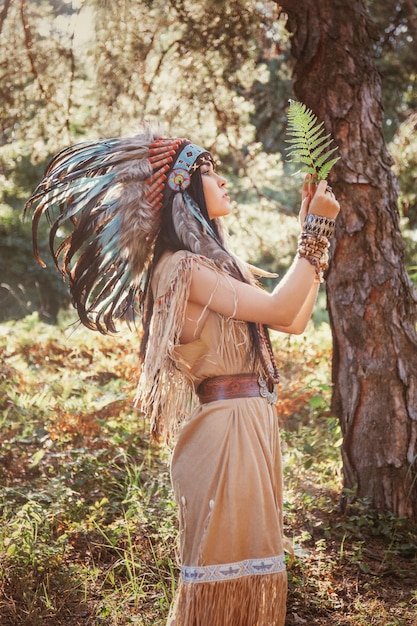 Retrato de mulher indiana ao ar livre mulher com roupas boho segurando uma folha de samambaia