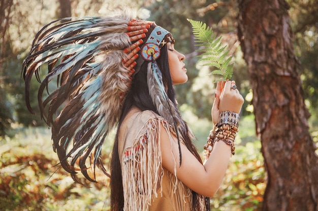 Retrato de mulher indiana ao ar livre mulher com roupas boho segurando uma folha de samambaia