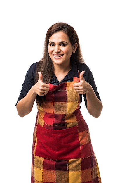 Retrato de mulher indiana chef ou cozinheira de avental apresentando apontando com sinal de ok polegares para cima ou mãos postas em pé isolado sobre fundo branco