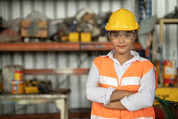 Retrato de mulher inteligente trabalhadora de raça asiática com sorriso de pé de traje de segurança