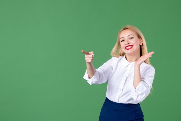 retrato de mulher jovem apontando no livro de parede verde para professores universitários