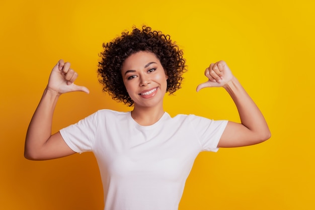 Retrato de mulher jovem apontando o dedo sobre fundo amarelo