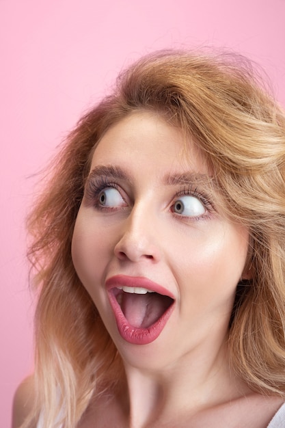 Foto retrato de mulher jovem caucasiana isolado no fundo rosa do estúdio. linda modelo feminino.