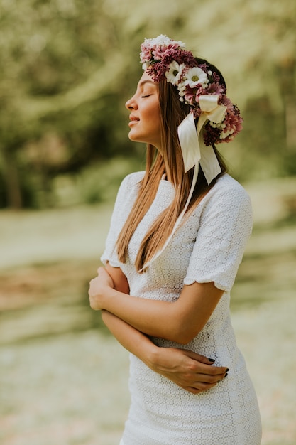 Retrato, de, mulher jovem, com, grinalda, de, flores frescas, ligado, cabeça, parque