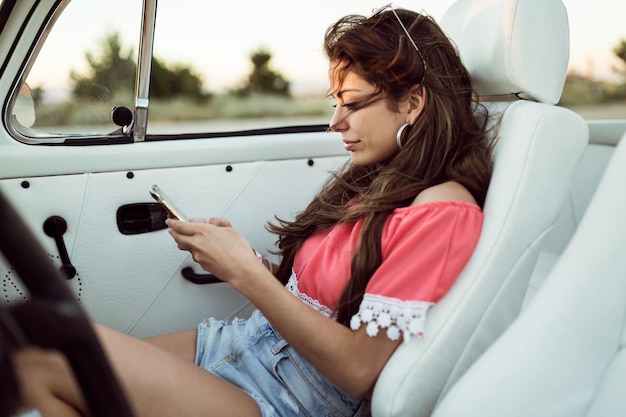 Retrato de mulher jovem, dirigindo em viagem num lindo dia de verão.