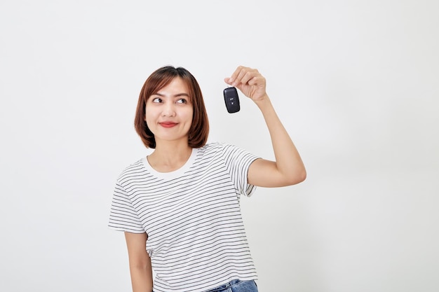 Retrato de mulher jovem e bonita asiática com chave de carro