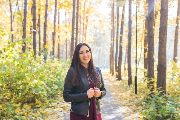 Retrato de mulher jovem e bonita caminhando ao ar livre no outono