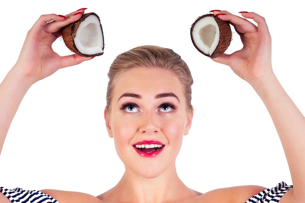 Retrato de mulher jovem e bonita com a pele perfeita segurando um coco no estúdio.