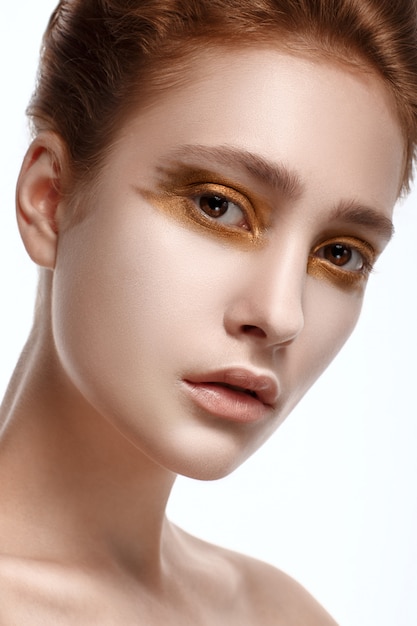 Retrato de mulher jovem e bonita com maquiagem perfeita dourada brilhante