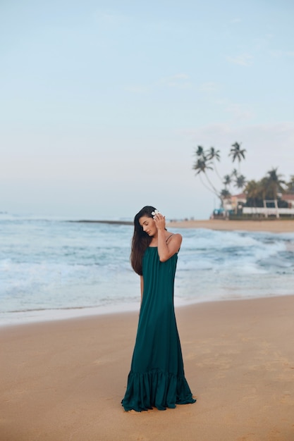 Retrato de mulher jovem e bonita com vestido na praia. menina bonita na praia tropical. conceito de liberdade, férias, praia, fundo do céu.