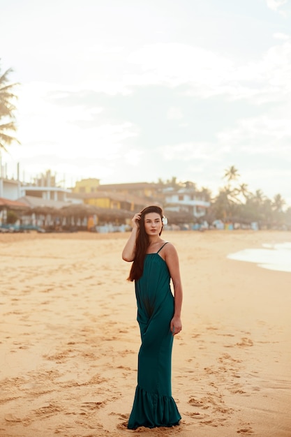 Retrato de mulher jovem e bonita com vestido na praia. Menina bonita na praia tropical. Conceito de liberdade, férias, praia, fundo do céu.