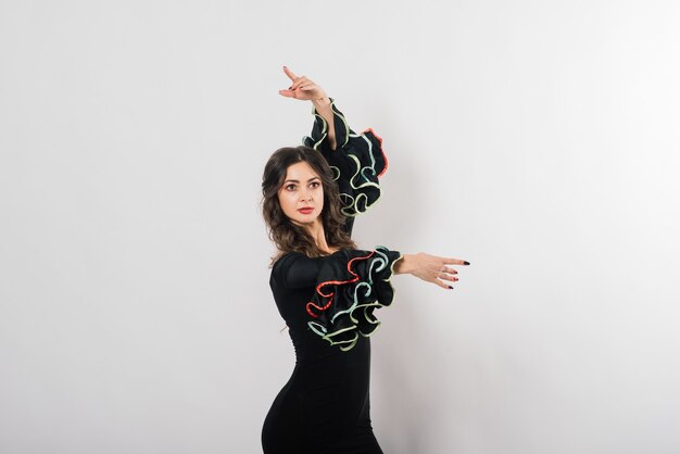 Retrato de mulher jovem e bonita dançando flamenco com ventilador no estúdio