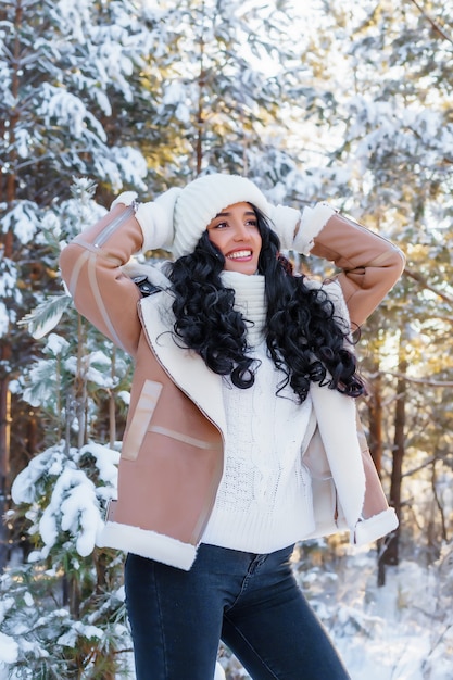 Retrato de mulher jovem e bonita em um dia ensolarado de inverno no fundo da floresta.