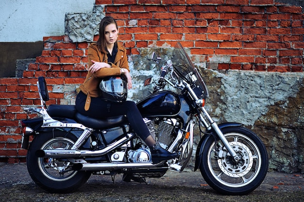 Retrato de mulher jovem e bonita posando com moto