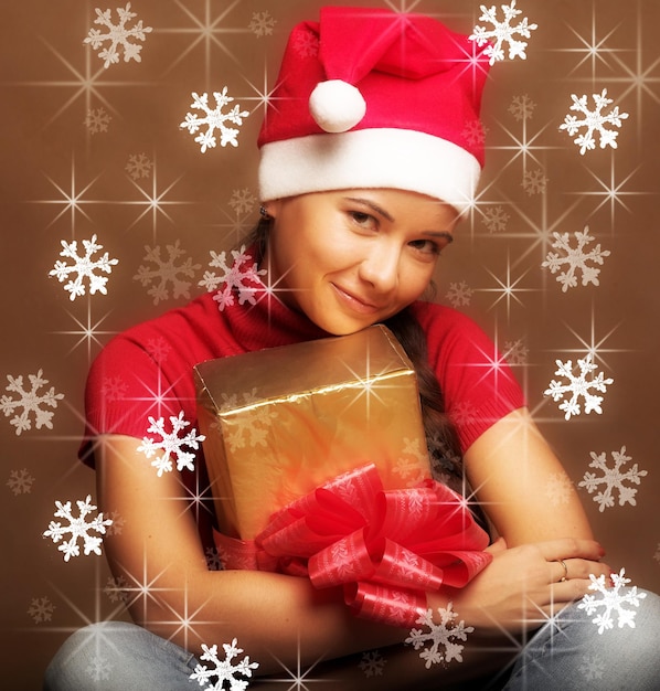 Retrato de mulher jovem e bonita usando chapéu de papai noel com p