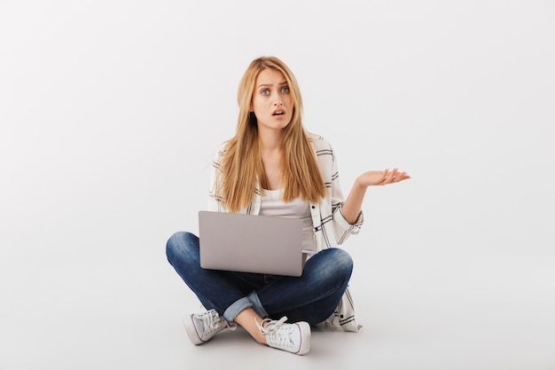 Retrato de mulher jovem e confusa com um laptop