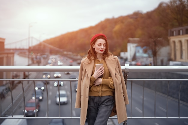 Retrato de mulher jovem elegante vestindo casaco de outono e boina vermelha ao ar livre. Jovem tenra