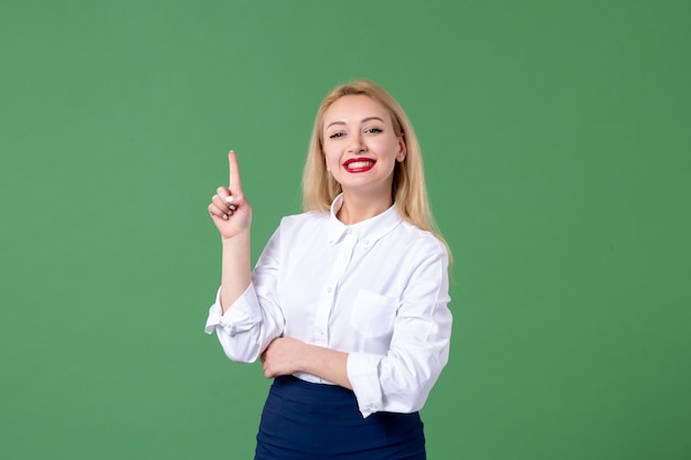 retrato de mulher jovem em roupas conservadoras sorrindo parede verde aluna da aula de estudo da escola