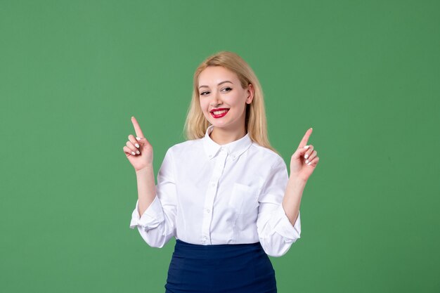 retrato de mulher jovem em roupas conservadoras sorrindo parede verde estudante lição estudo escola feminino