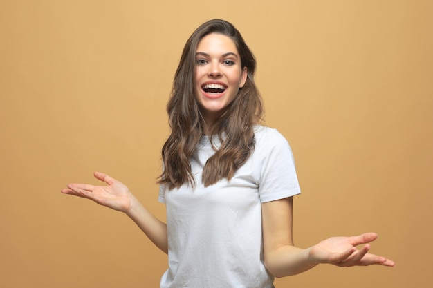 Retrato de mulher jovem espantada sobre fundo bege.