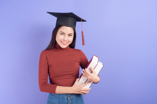 Retrato de mulher jovem estudante universitário com chapéu de formatura