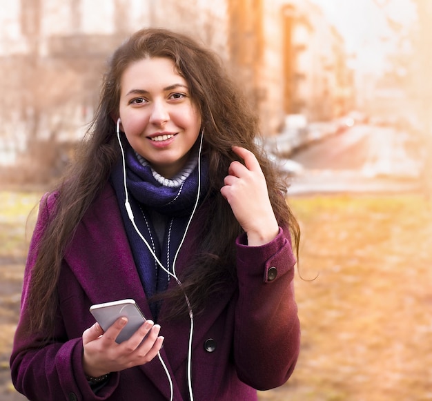 Foto retrato de mulher jovem feliz em fones de ouvido na rua da cidade