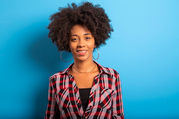 Retrato de mulher jovem legal rindo contra parede azul