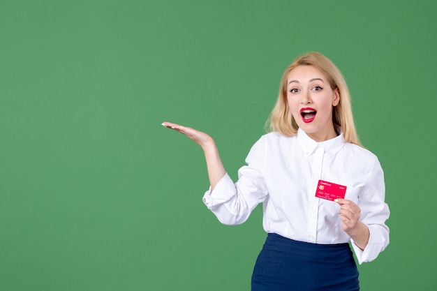 retrato de mulher jovem posando com cartão de crédito parede verde professor dinheiro banco de negócios