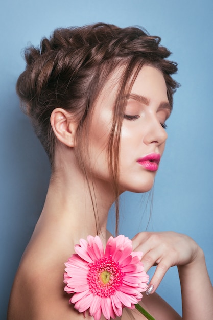 Retrato de mulher jovem romântico com flor rosa. Foto de moda primavera. Inspiração da primavera e verão.